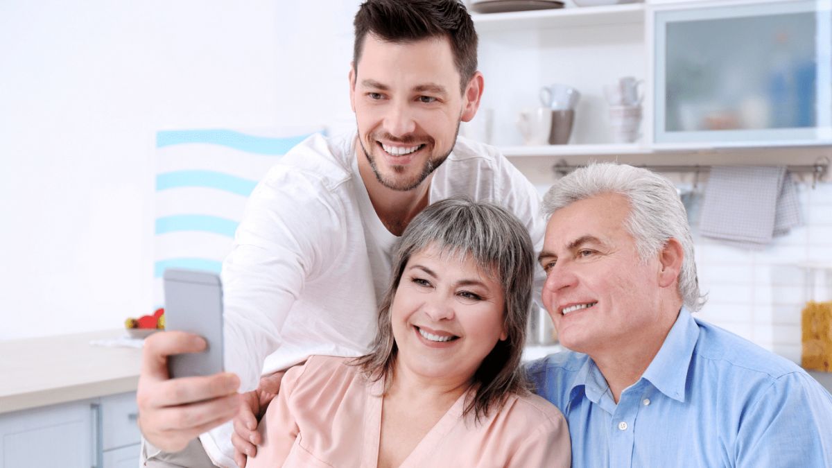 A person posing for a picture with parents - Australia Wait Times Stretch to 40 Years for Parents