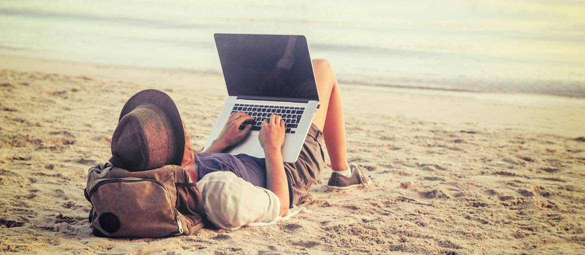 A digital nomad working on a beach - Countries Offering Digital Nomad Visas For Less Than $1500