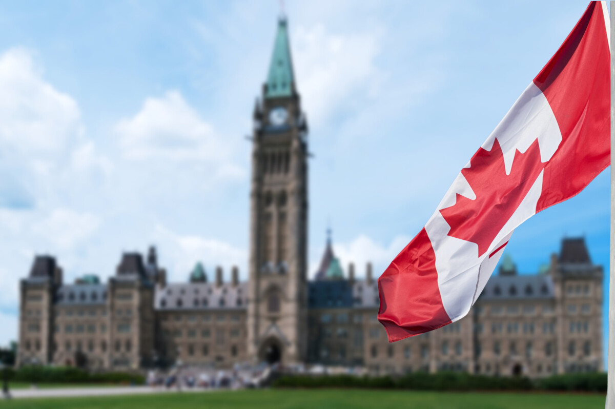 A Canadian flag with Centre Block building in the background - Federal Workers strike in Canada