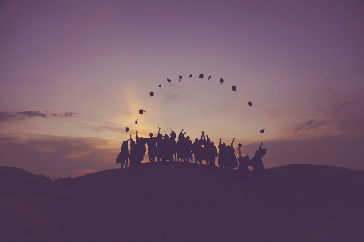 Group of students throwing their graduation caps in the air.