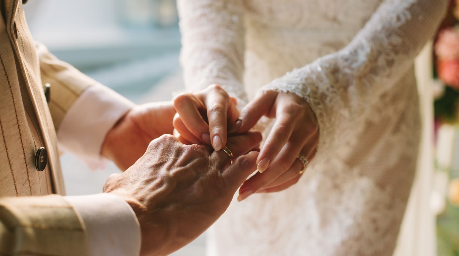 A couple exchanging rings in a wedding ceremony - Bringing your partner to the UK