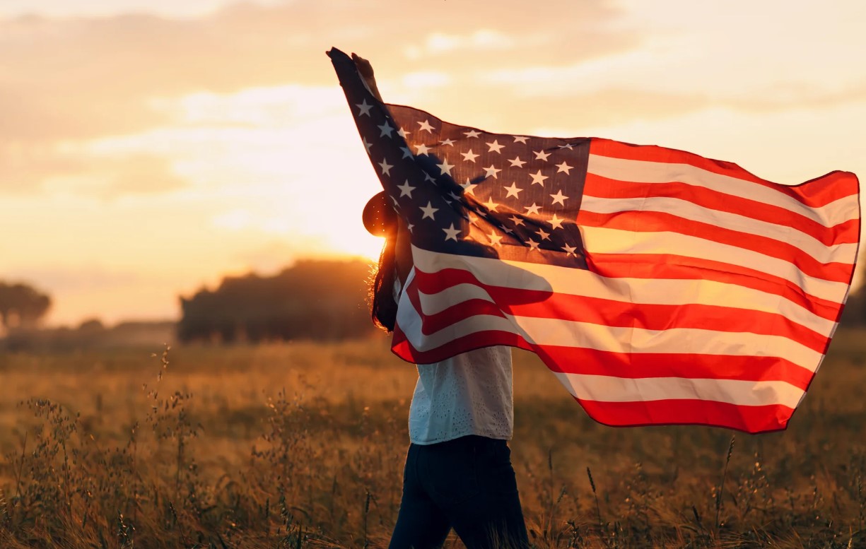 A person holding a US flag -  Trump Restates Controversial Comment on Immigration